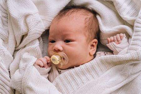 image of a baby with dummy in its mouth